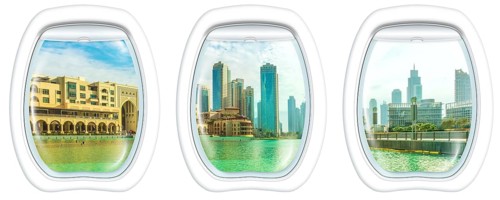 Three plane windows on Dubai skyscrapers skyline, United Arab Emirates, from a plane on the