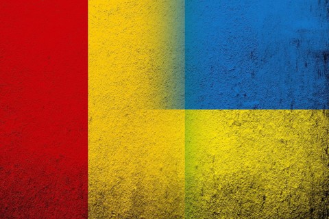 The Republic of Guinea National flag with National flag of Ukraine. Grunge background