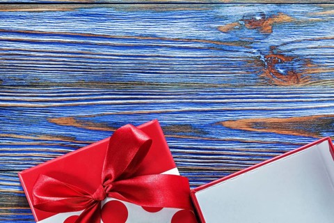 Red packed present box on vintage wooden board