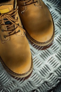 Pair of leather protective boots on fluted metal sheet