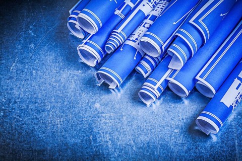 Blue rolled blueprints on metallic background construction concept