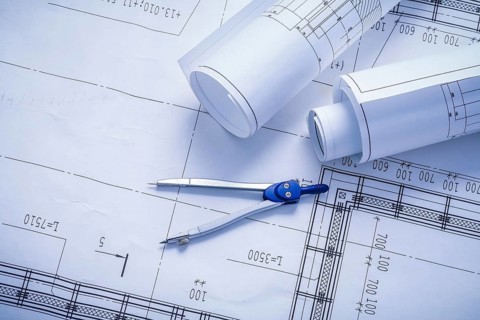 Vertical version compass and rolled blueprints close up