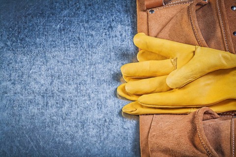 Pair of protective gloves toolbelt on metallic background construction concept