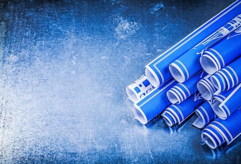 Blue rolled construction plans on metallic background copy space maintenance concept