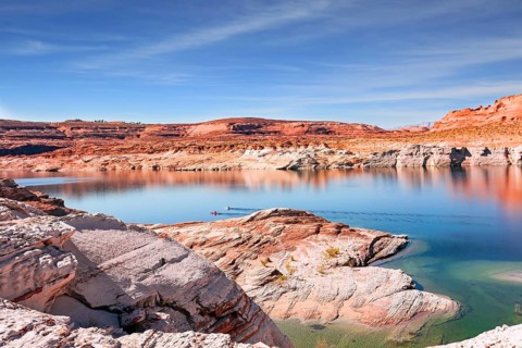 Lake Powell. The water reflects the surrounding shores. The smooth emerald water of the lake