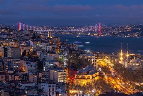 A picture of the buildings of the Beyoglu district and the Bosphorus Bridge at night