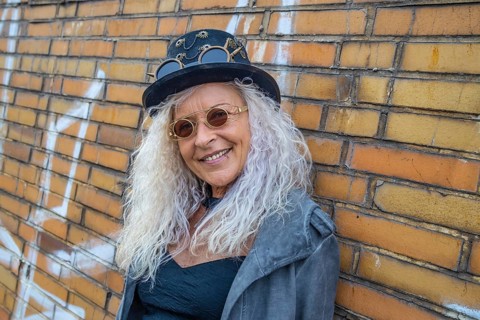 Schöne Steam Punk Lady steht auf einer Backsteinmauer Hintergrund