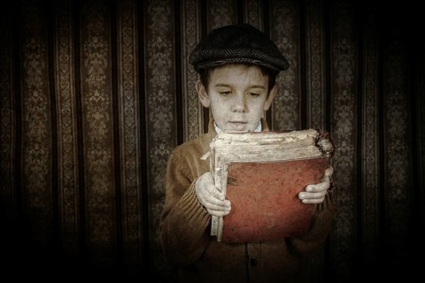 Child with red vintage book. Vintage clothes and hat