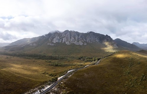 An aerial view of Gordon River Rd at the Sentinel range of mountains near Bitumen Bones Sculpture
