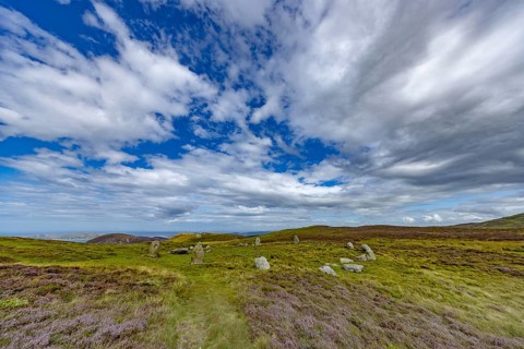Druids Circle, stone circle in wide landscape with pastures in the mountains, Penmaenmawr,
