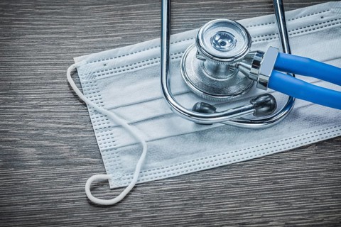 Disposable face mask stethoscope on wooden board