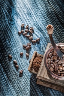 Coffee grinder beans on vintage wooden board