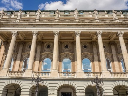A classic façade with high columns and several windows symbolises monumental architecture,