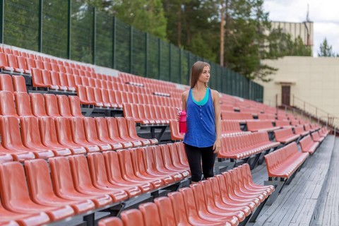 Girl with a bottle of pink at the stadium