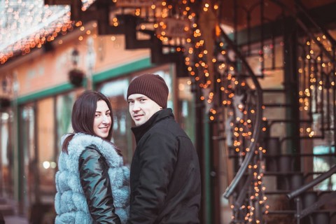 Romantic couple walking in the winter under the snow in Christmas time
