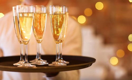 Champagne glasses on tray in bright lights. Party or celebration