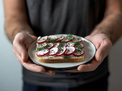 Hands takes plate with vegan sandwich. Healthy appetiezer - whole wheat bread toast with