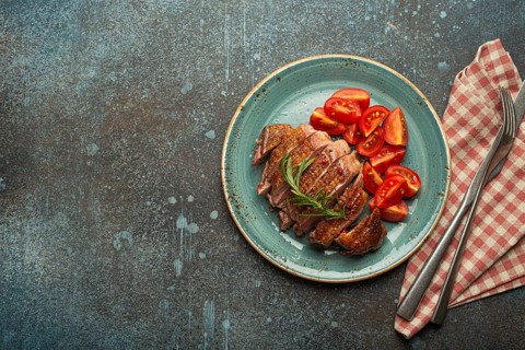 Delicious roasted sliced duck breast fillet with golden crispy skin, with pepper and rosemary, top