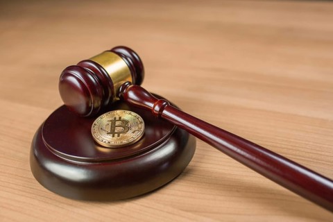 Bitcoin regulation. BTC cryptocurrency coin and judge gavel on a desk. Banned currency or law