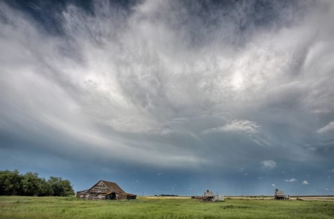 Abandoned Farm with storm clouds in the Canadian Prairie
