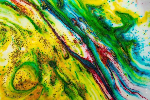 Multicoloured background of bright colours covered with gold sparkles