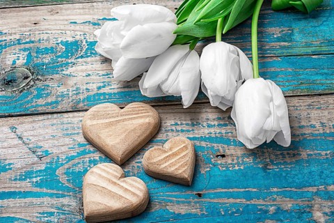 Hand-carved symbolic wooden heart on a background white Tulip