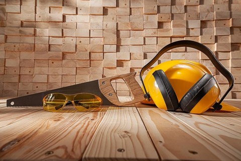Construction Carpentry Concept. Yellow Safety Goggles Helmet And Earphones. Classic Handsaw With