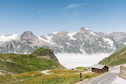 Scenic view of Alpine road through valley with sea of clouds. Grossglockner, Austria. Space for