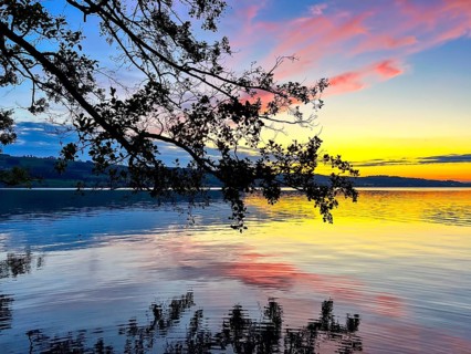 Colourful sunset on Lake Sempach with pink and blue sky reflections in the water, Sempach, Lucerne,