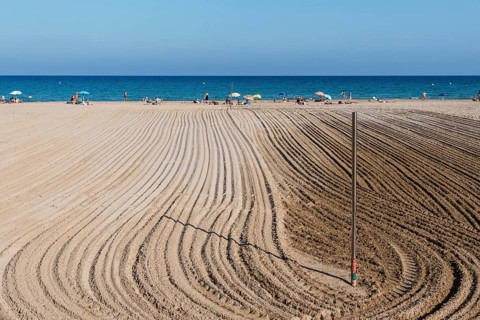 Alicante, Spain, October 13, 2023: Furrows in the sand from sand cleaning raking in the beach of