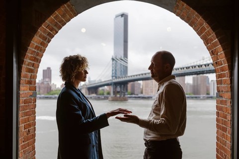 People by the window with Manhattan Bridge in the background, Brooklyn District in New York City -