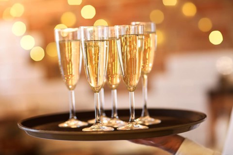 Champagne glasses on tray in bright lights. Party or celebration