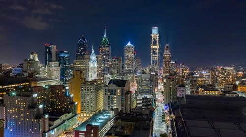 Aerial view night sky over the neighborhoods and streets of Philadelphia PA USA