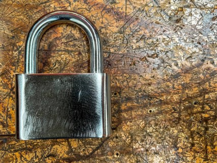 Metal padlock on a wooden background