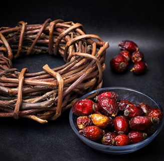 Rose in white bowl on background licorice root bound in coil