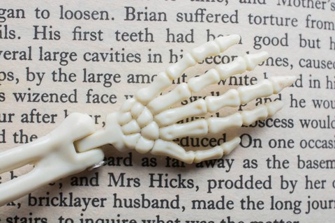 Skeletal hands book text. death, halloween and mistery concept