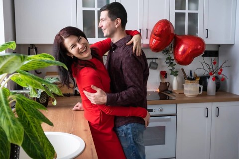 Man and woman in love date at home in kitchen happy hugs. Valentine's Day, happy couple, love story