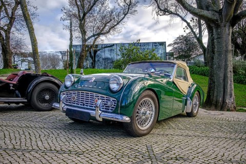 Lisbon, Portugal, Jan 20, 2024: A classic green Triumph TR3A soft top drophead car cobblestone
