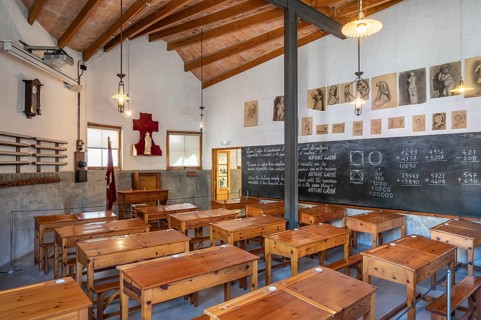 Classroom around 1900 with wooden desks and slate board with maths problems in the school for the