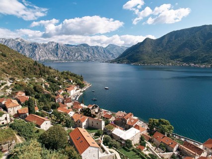 View of the Bay of Kotor over the red roofs of old houses. Perast, Montenegro. Drone.