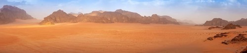 Panorama wide angle of an empty Wadi Rum desert in spring, with some clouds in the air. Travel and