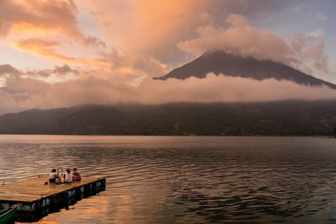 Tourists on a mooring enjoying the sunset, Lake Atitlan and San Pedro volcano, Santiago Atitlan,