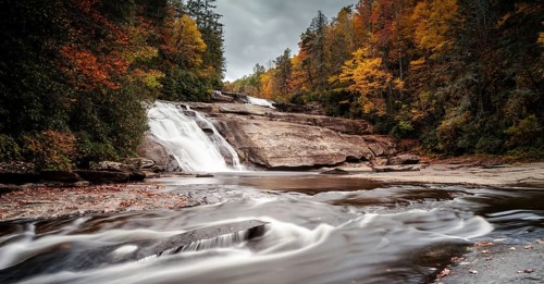 Triple Falls waterfall in fall color forest in the Appalachian mountains of North Carolina