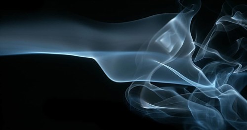Smoke of Cigarette rising against Black Background