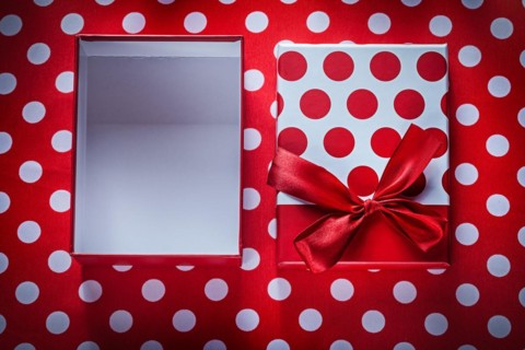 Opened present box on polka-dot red fabric celebrations concept