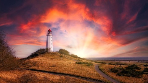 Lighthouse on the island of Hiddensee at sunset with a dramatic sky