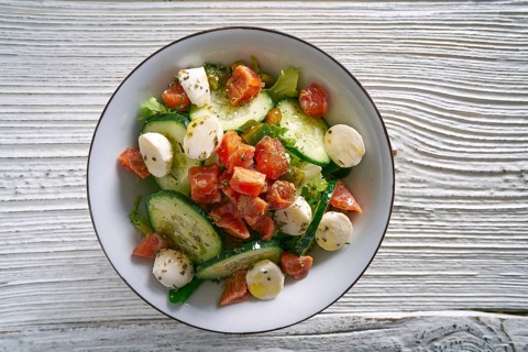 Salmon salad with mozzarella tomato cucumber on bowl