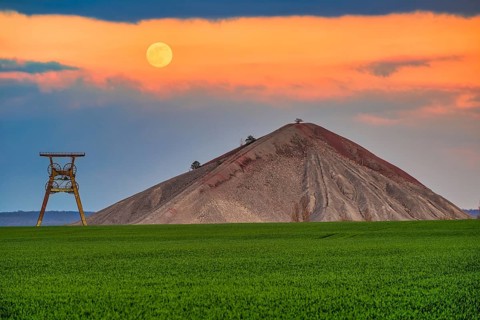 A view of an overburden heap in saxony-anhalt with a winding tower at moonrise