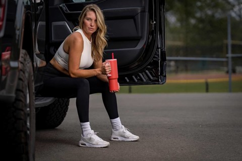 A gorgeous blonde model, dressed in sleek workout clothes, takes a well-deserved break after an