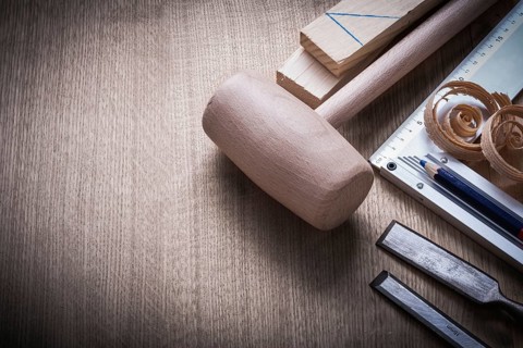 Wooden bricks mallet curled up scobs chisels try square pencil on wood board construction concept